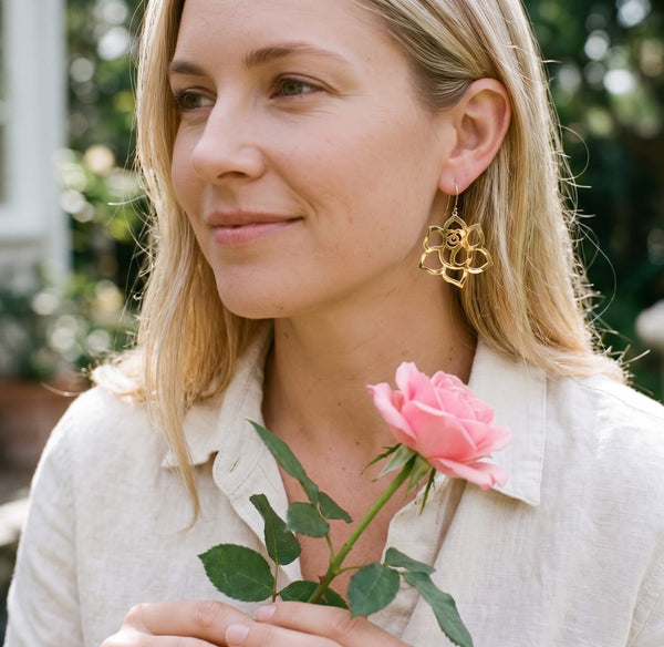 Rose Flower Earrings in yellow gold, worn with a pink rose